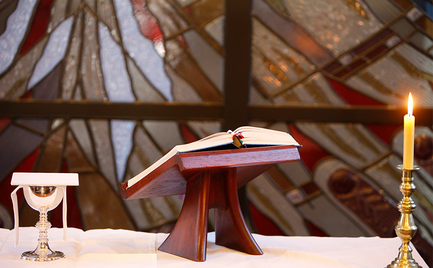 Church alter with bible and candle