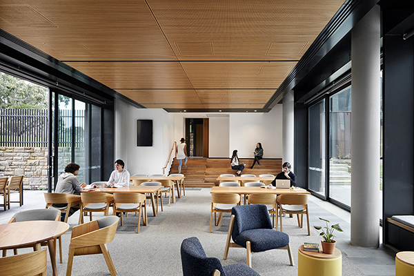 A room with desks and chairs and students studying.