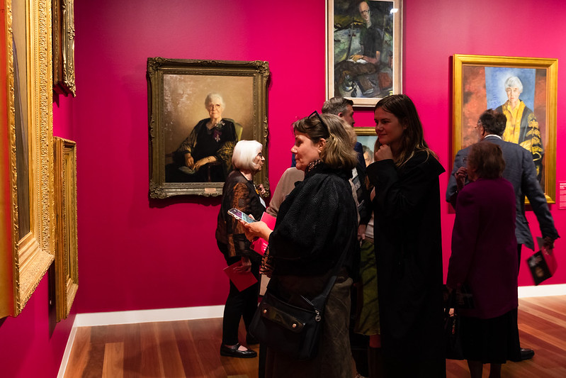 Line of people in the gallery admiring the artworks