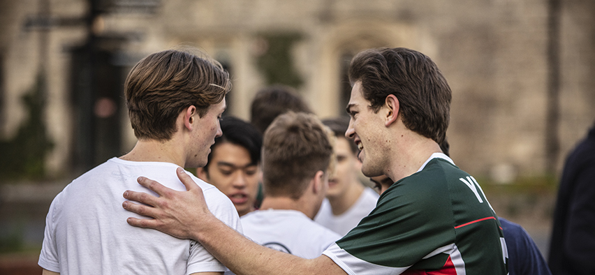 Candid image of a group of boys playing on the Bulpadock lawn.