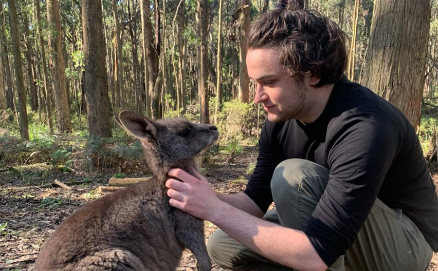 Dan Adamson patting a wallaby