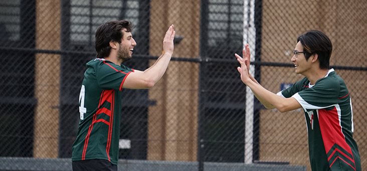 Two boys from team Trinity going to high-five after a game of intercollegiate soccer.