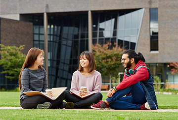 Pathways School students sitting on a lawn outside the Gateway building