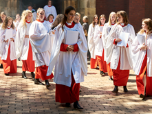 Group of girls walking after their choir practice in their white gowns and red bottoms