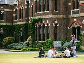 Students enjoying the picturesque Trinity College grounds in front of the most historic building
