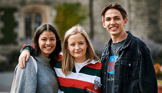 Smiling students, one of them wearing a Trinity jersey
