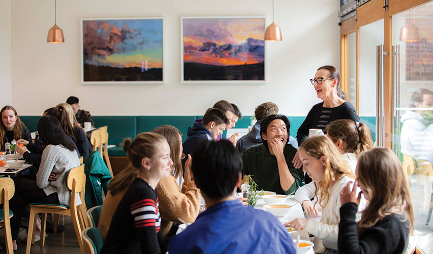 Candid image of Trinity college residents hanging out in the resiential cafe.