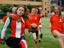 A group of Trinity girls playing soccer and having fun on the field.